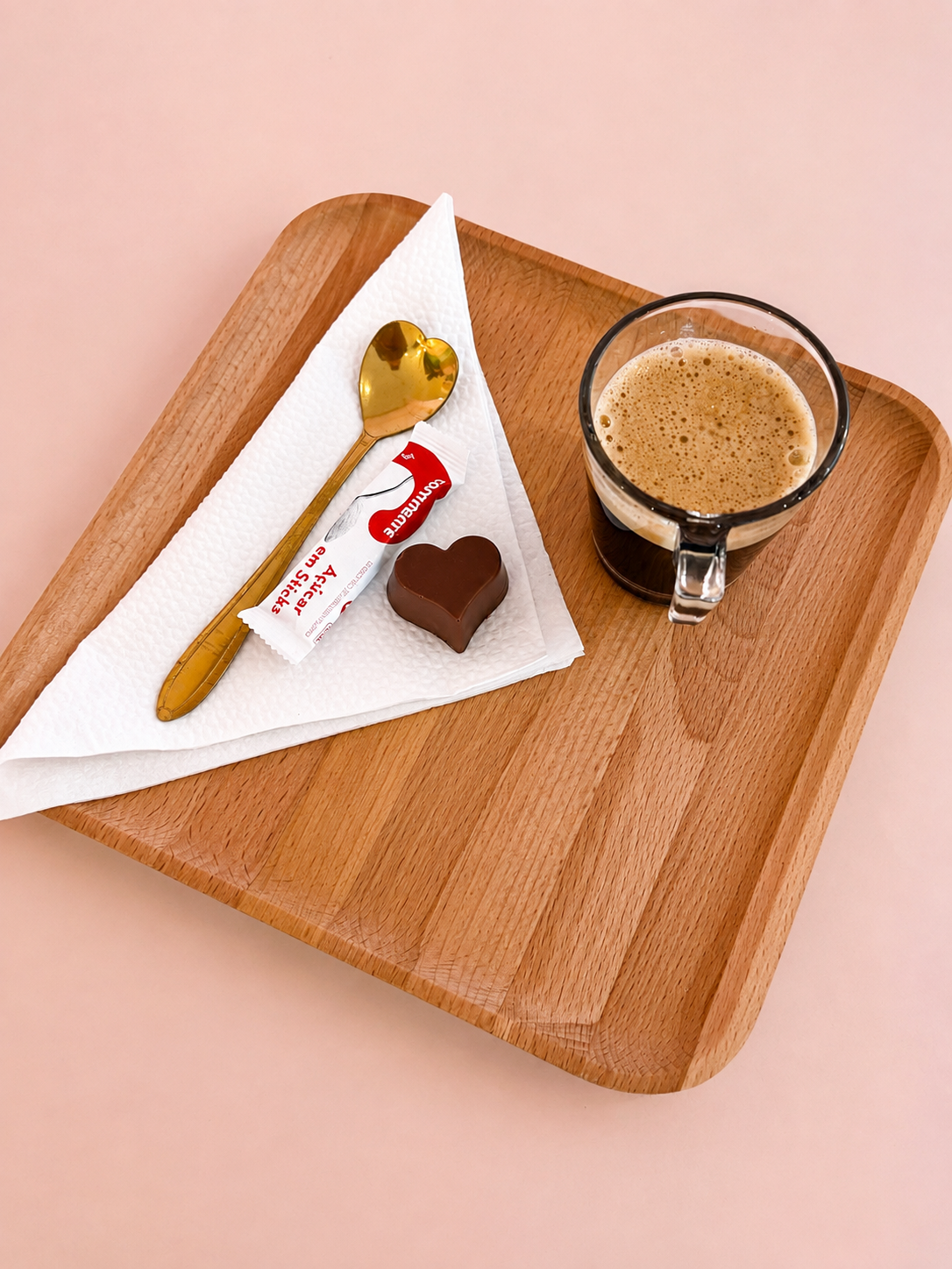Tabuleiro com café, chocolate e colher dourada oferecido às clientes