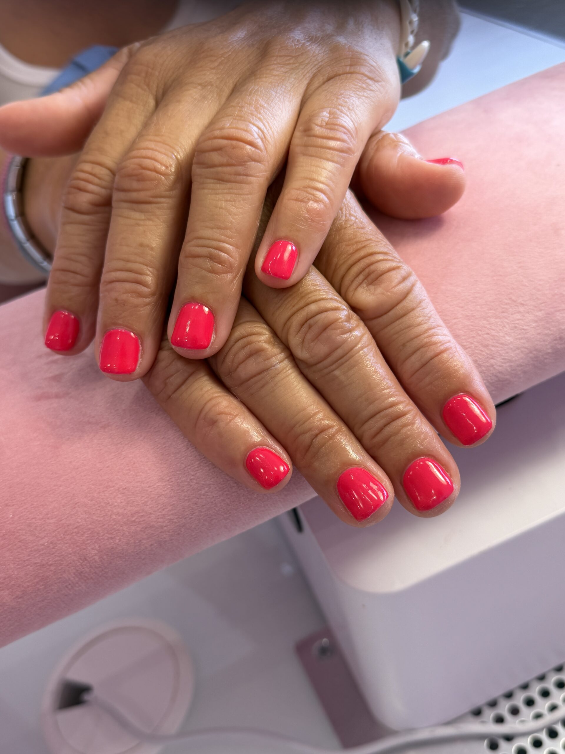 Unhas curtas em verniz de gel rosa-coral, feitas no Hit Nails Mafra